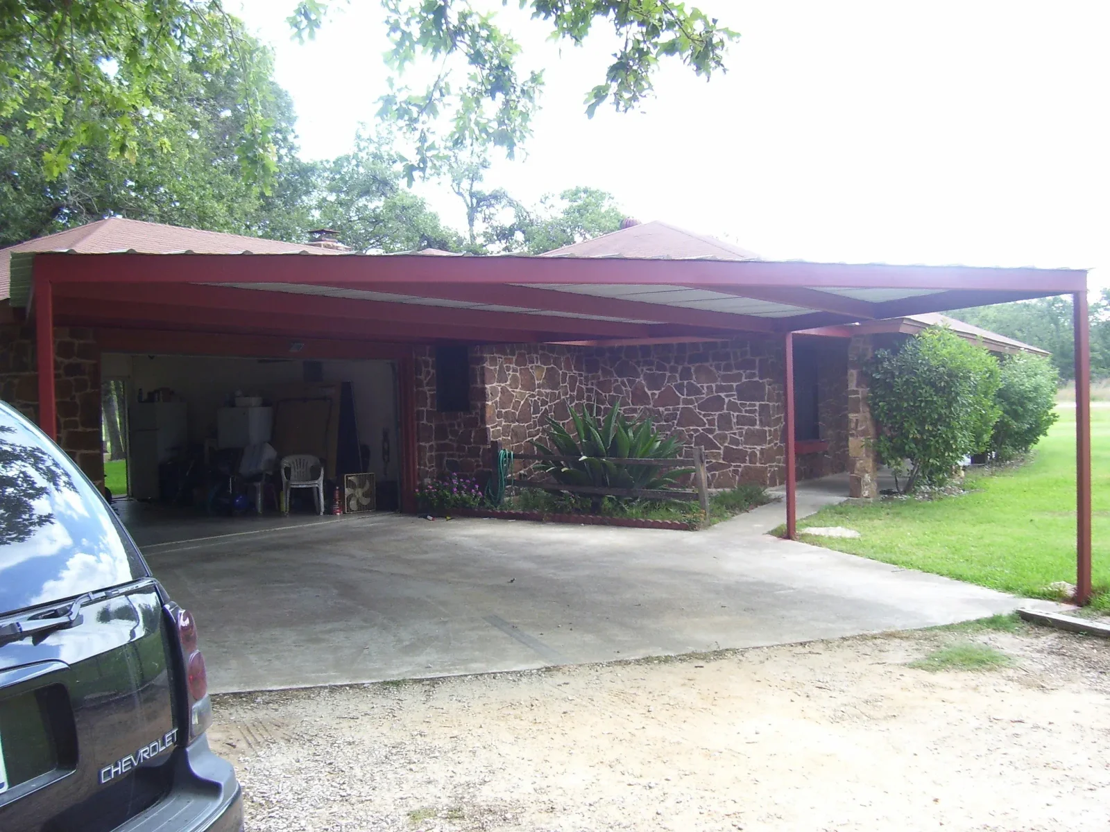Custom steel carport protecting vehicles in Texas
